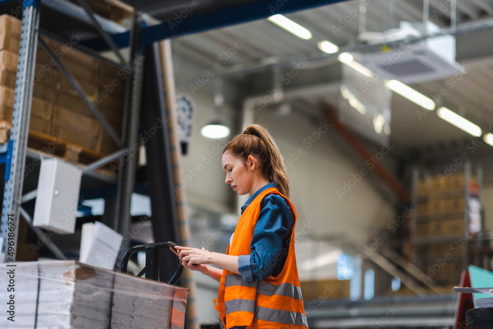 Obraz premium Woman with tablet in factory storehouse checking location of goods