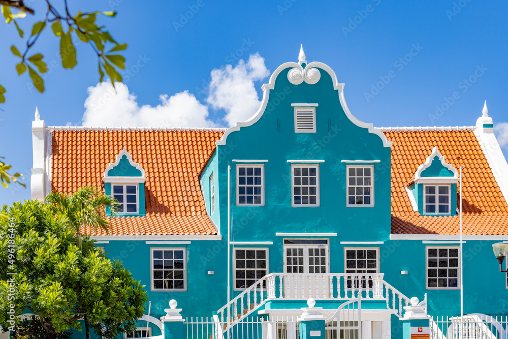 Beautiful building with a turquoise facade, white details and an orange roof in Willemstad, Curacao