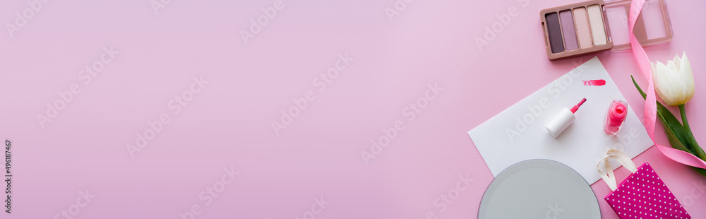 top view of brushstroke on card near nail polish, white tulip, eye shadow and shopping bag on pink, banner. top view of brushstroke on card near nail polish, white tulip, eye shadow and shopping bag on pink, banner.
