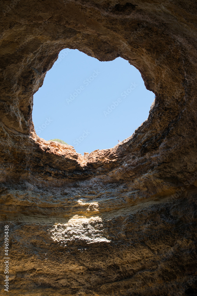 Natural cave at Benagil, with blue sky. Coast of Algarve, Portugal