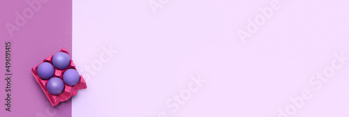Holder with painted Easter eggs on lilac background with space for text © Pixel-Shot