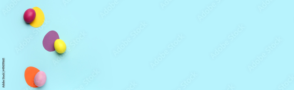 Colorful painted Easter eggs on light blue background with space for text