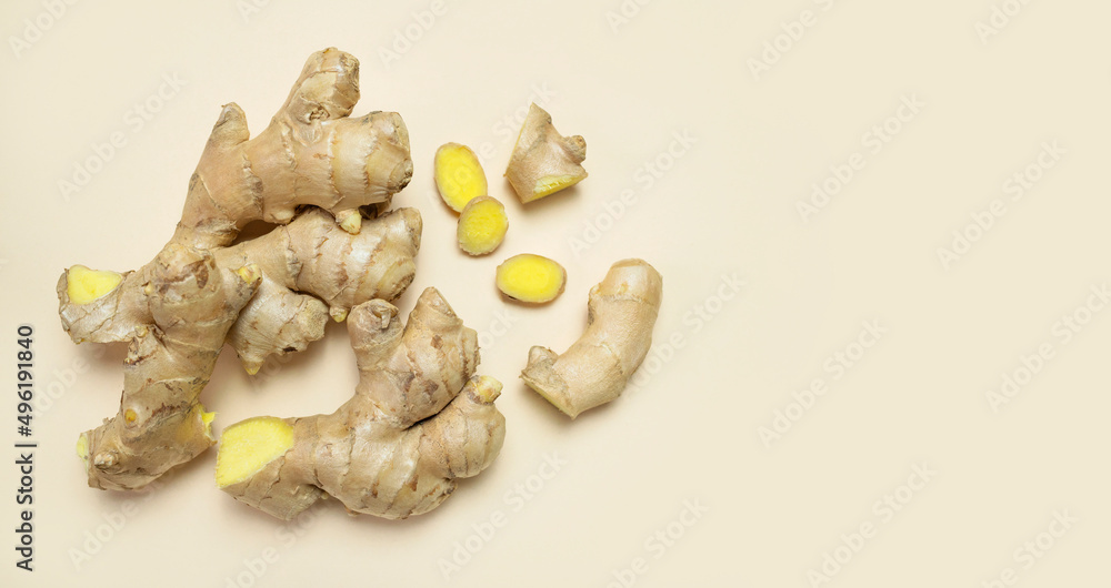 Fototapeta premium Fresh ginger root chopped ginger pieces on beige background top view flat lay. Spice for cooking, herbal tea with ginger to boost immunity. Natural organic ginger for health medicine protection colds