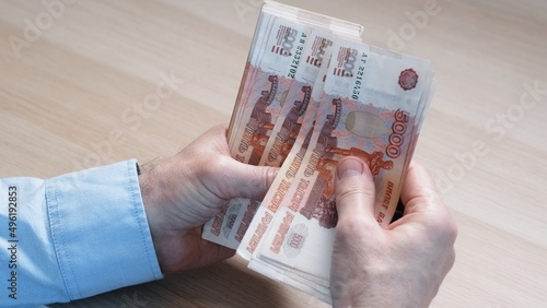 Close-up of hands counting five-thousandth banknotes of the Russian ruble. Men's hands count Russian money 5000 banknotes. business, finance