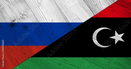 Background with flag of Russia and Libya on divided wooden board. 3d illustration
