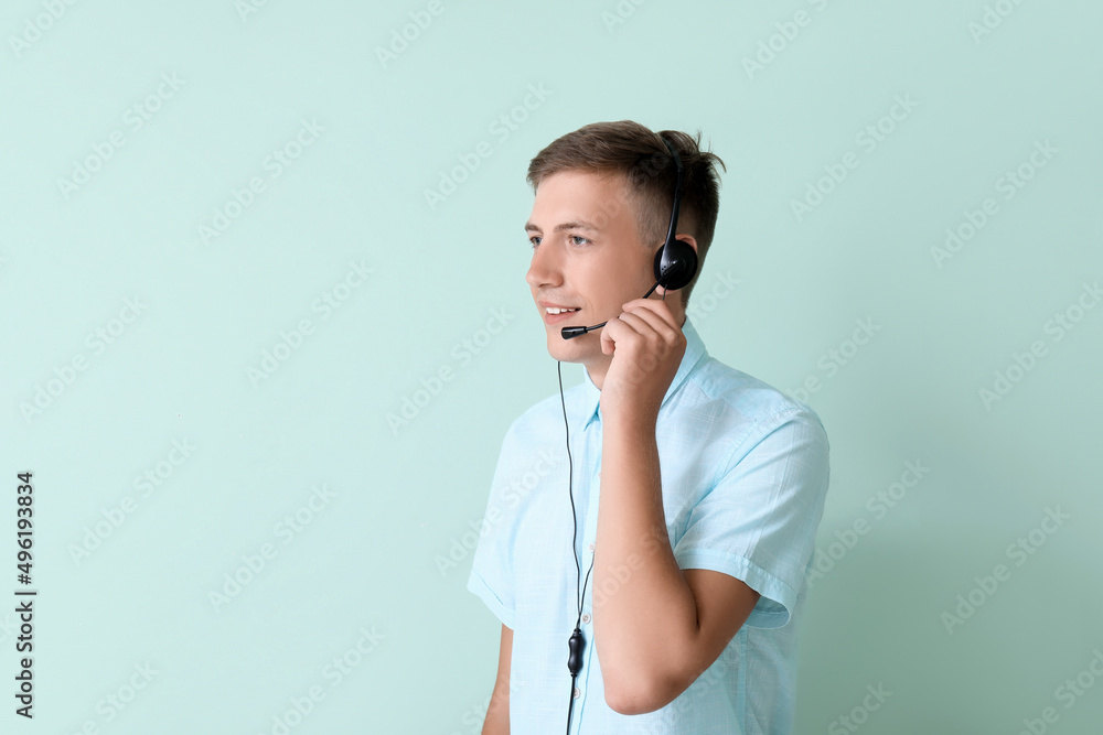Young consultant of call center in headset on blue background Young consultant of call center in headset on blue background