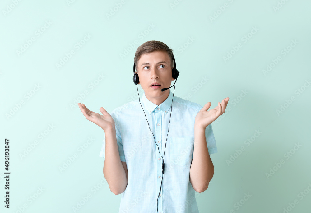 Confused consultant of call center in headset on blue background Confused consultant of call center in headset on blue background