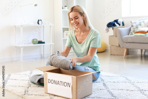 Young woman putting clothes...