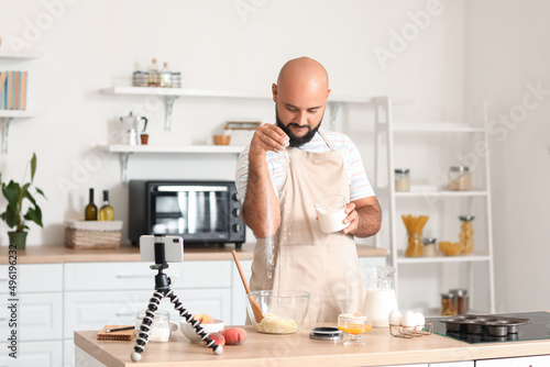 Handsome man making dough w...