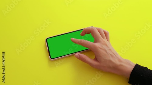 Gestures pack on Green Mock-up Screen Chroma Key phone. Female hand touching, zoom in, sliding, swiping, scrolling on smartphone screen in orizontal mode. Internet, communications concept. photo