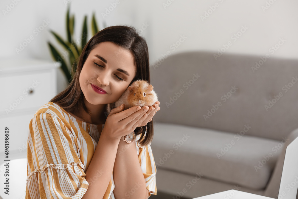 Beautiful young woman with cute guinea pig at home Beautiful young woman with cute guinea pig at home