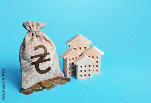 Houses and ukrainian hryvnia money bag. Real estate investment and rental business. Increasing property value. Fair market price. Home taxation. Residential or property income. Municipal budget.