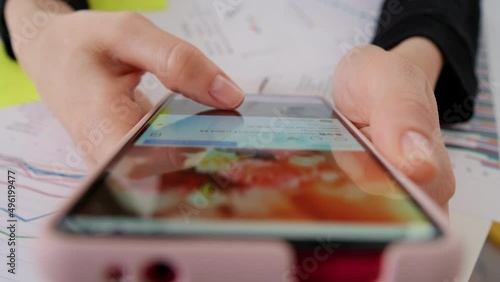 Person using smartphone, browsing through pictures on social network. Close-up Macro. Finger scrolling social media app feed, information search.