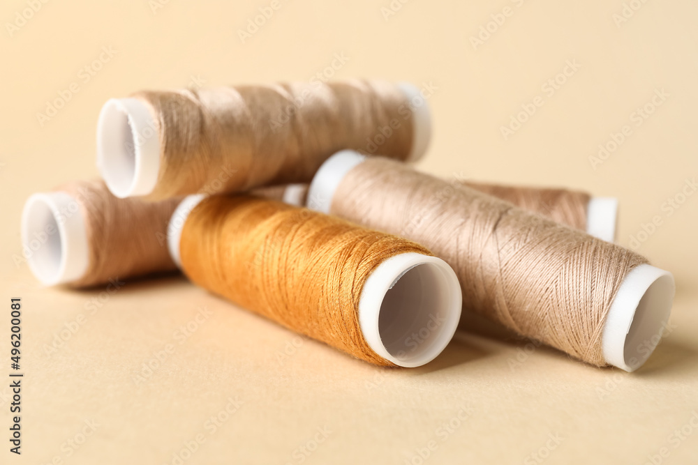 Beige sewing thread spools on light background Beige sewing thread spools on light background