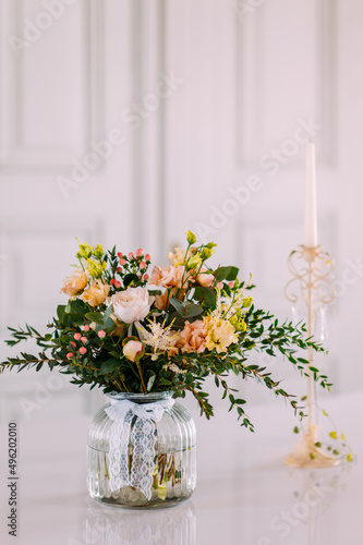 schöne Blumen Dekoration in einer Blumenvase vor weissem Hintergrund auf einer Hochzeit