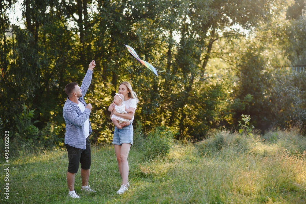 Obraz premium Happy young family spending time together outside in green nature.