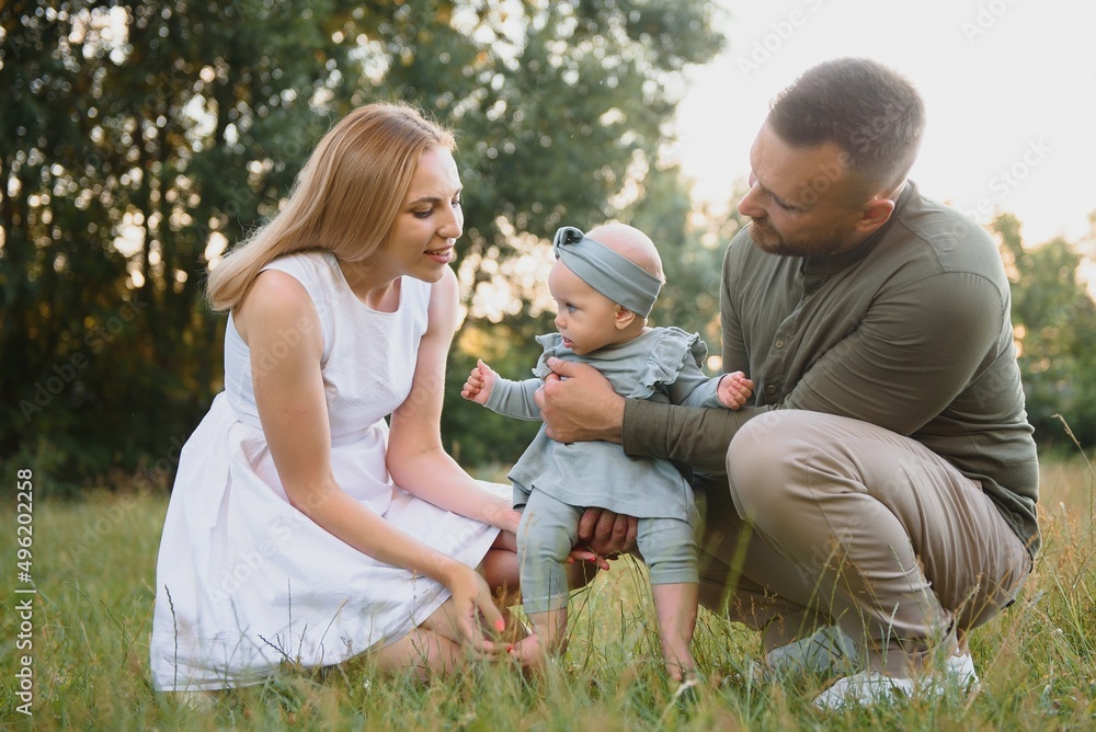 Fototapeta premium Happy young family spending time together outside in green nature.