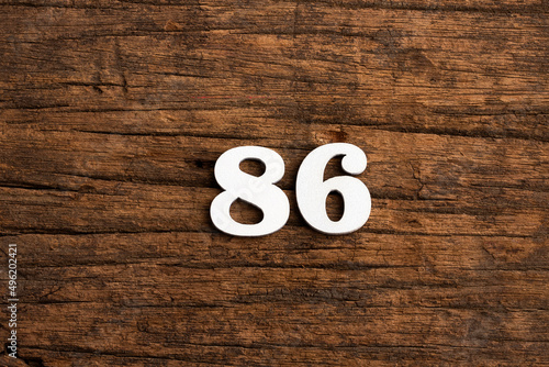 Number 86 - piece on rustic wood background photo