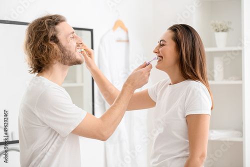 Funny young couple brushing...