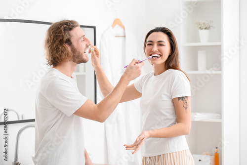 Funny young couple brushing...