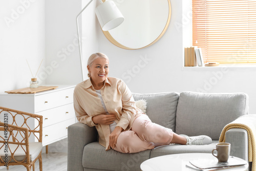 Mature woman sitting on sof...