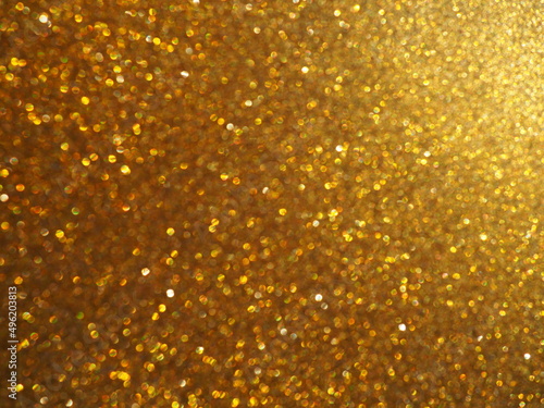 Bokeh light of gold glitters. Golden glitter texture background. Sparkling glitter wrapping paper with sequins and sparkles. Festive golden bokeh and glitter. Beautiful macro background photo