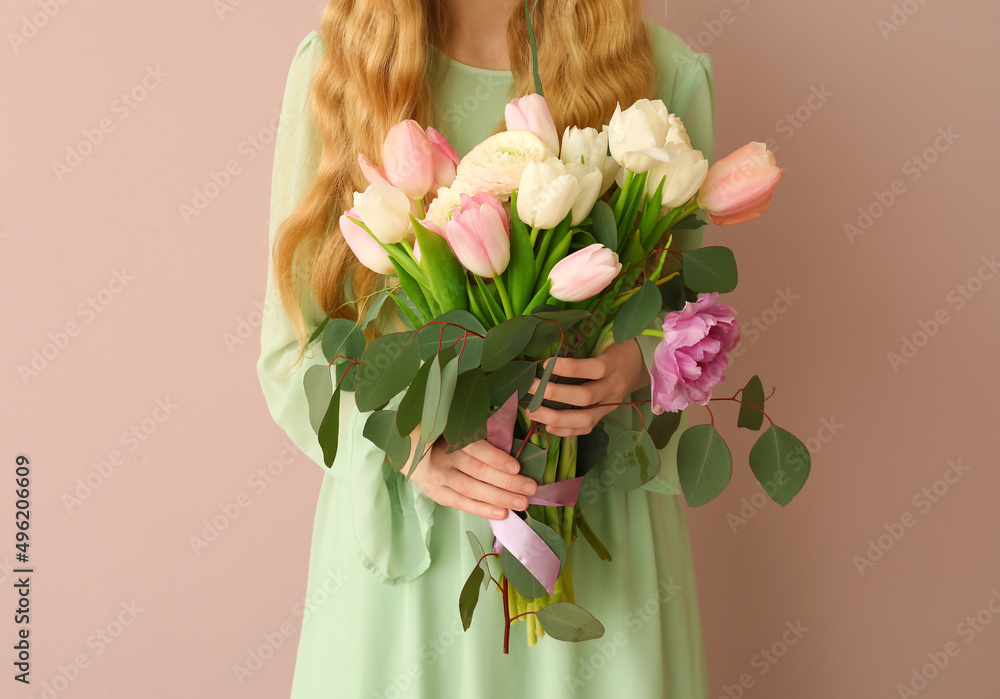 Young woman with bouquet of beautiful flowers on color background