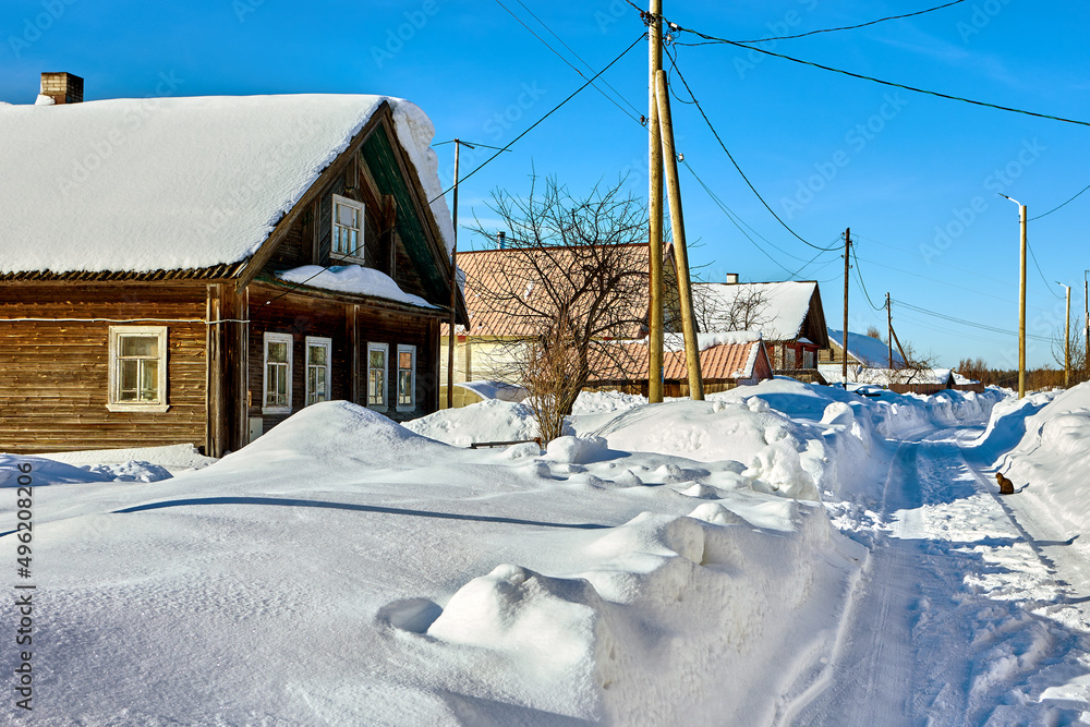 Northern latitudes during winter in countryside with rural buildings covered by snow.