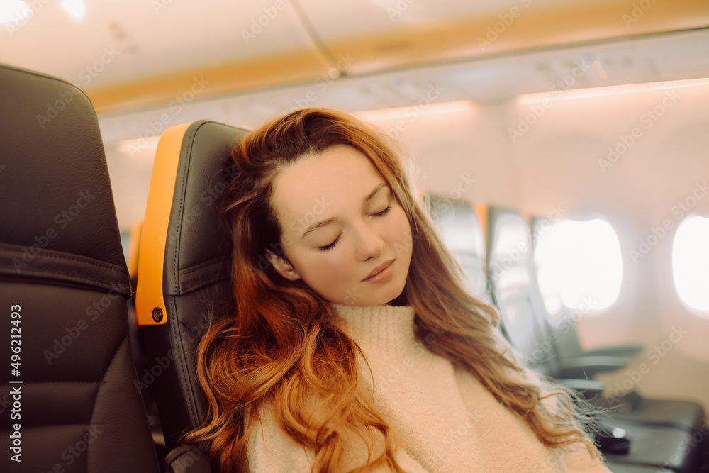 The girl is sleeping on an empty plane. Woman on a long flight, travel
