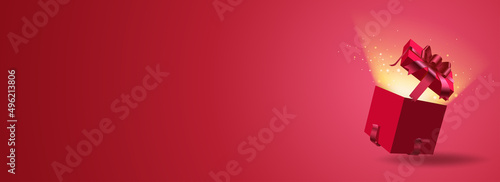 Red New Year and Christmas vector gift with a burgundy ribbon on a red background with an open box from which rays of light shine and balls of light fly out. Shopping for the holiday. Buy on promotion