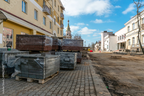 New paving slabs neatly stacked on pallets. Repair of sidewalks and replacement of paving slabs. Reconstruction of urban infrastructure. © Pokoman