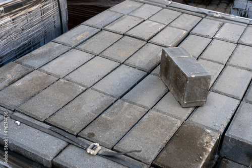 New paving slabs neatly stacked on pallets. Repair of sidewalks and replacement of paving slabs. Reconstruction of urban infrastructure.