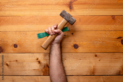 hand grabbing hammer and chisel on light wooden background - Labor Day