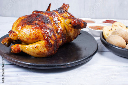 Roast chicken, traditional Colombian food, accompanied by boiled potato, arepa, sauces
