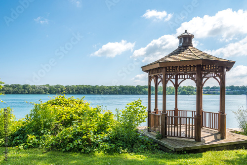 Tableau sur toile A wood gazebo over looks the Niagara River in Niagara on the Lake, Ontario, Canada on a blue sky day