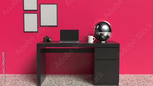 Home office desk with magenta wall and black table with laptop and disco ball
