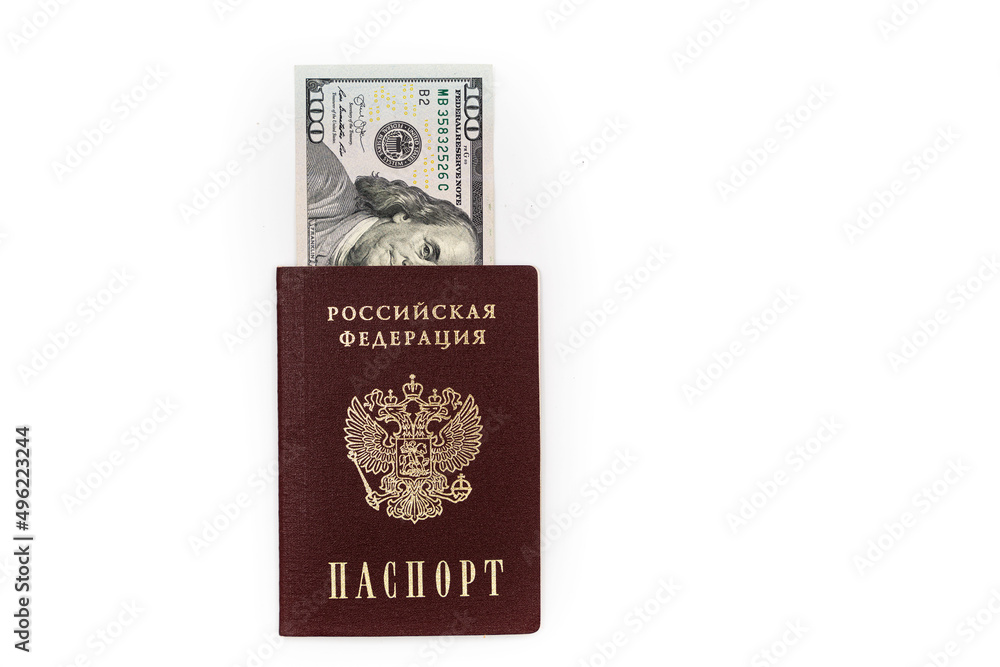 American dollars, 100 dollar bills lie in the passport of the Russian Federation, close-up on a white background American dollars, 100 dollar bills lie in the passport of the Russian Federation, close-up on a white background