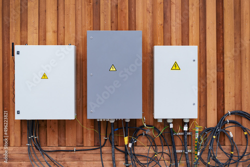 Electric meters and equipment cabinets on facade of wooden house installation