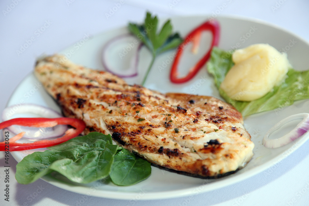 Grilled fillet perch fish (Turkish: Levrek) with vegetables on the dinner plate. Grilled fillet perch fish (Turkish: Levrek) with vegetables on the dinner plate.