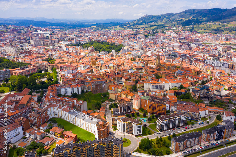 View from drone of residential areas of Spanish city of Oviedo on background on summer mountain landscape ..