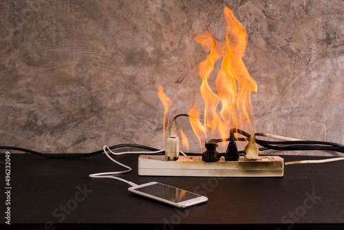 Bild auf Leinwand Short circuit An electrical outlet or electronic device bursts into flames while charging a mobile phone battery