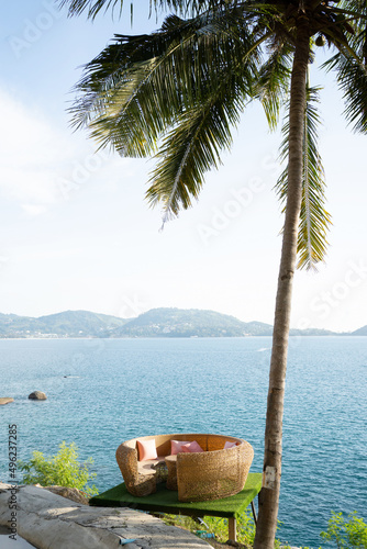 Fototapeta Naklejka Na Ścianę i Meble -  Wooden table top coconut palm trees swings seaside background.