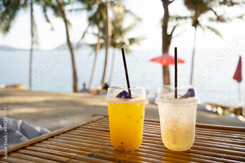 Orange juice on table seaside during sunset sky.