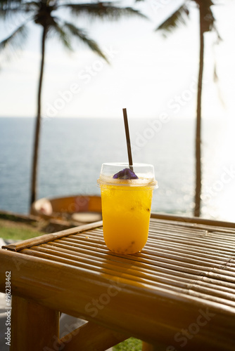 Orange juice on table seaside during sunset sky. 