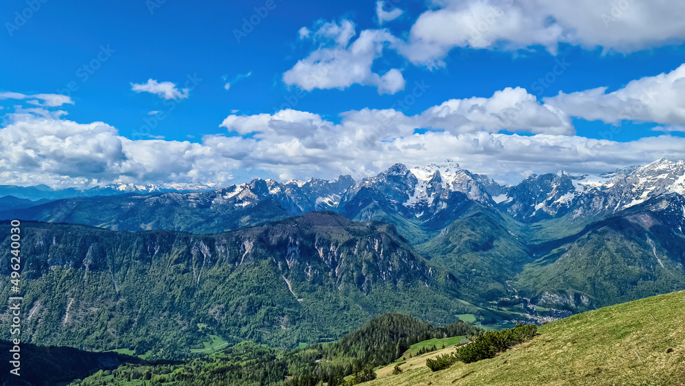 Mountain peak of Hahnkogel (Klek) with panoramic view in spring on the Karawanks, Carinthia, Austria. Borders Austria, Slovenia, Italy. Triglav National Park. Alpine meadows. Alm. Snow fields melting