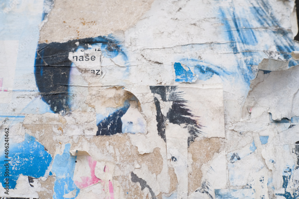 Fototapeta premium Grungy street poster background. Torn and ripped paper texture. Abstract collage layers of vintage street poster.