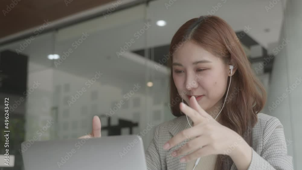 Happy young business woman wearing headphones, Talking and video calling on laptop. Smiling and happy. Soft focus. Happy young business woman wearing headphones, Talking and video calling on laptop. Smiling and happy. Soft focus.