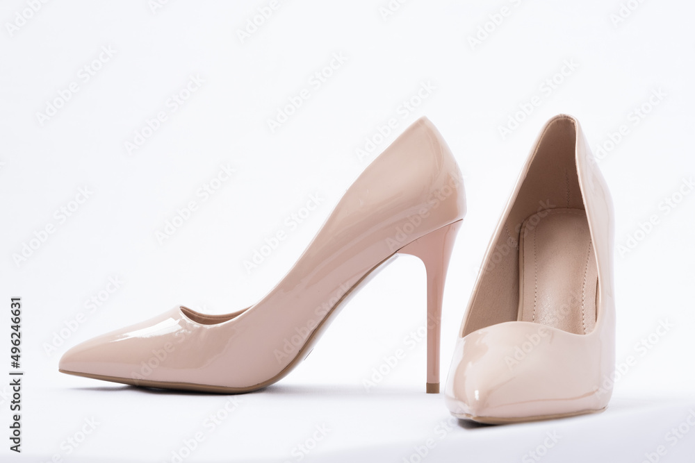 Elegant beige women's shoes with high heels. White background. Patent leather. Side view