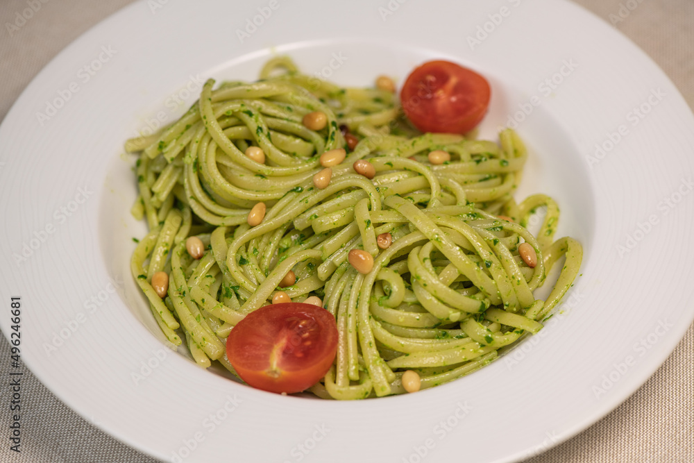 green spinach spaghetti with cheese and tomato on wooden table. High quality photo green spinach spaghetti with cheese and tomato on wooden table. High quality photo