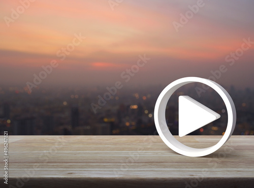 Play button 3d icon on wooden table over blur of cityscape on warm light sundown, Business music online concept